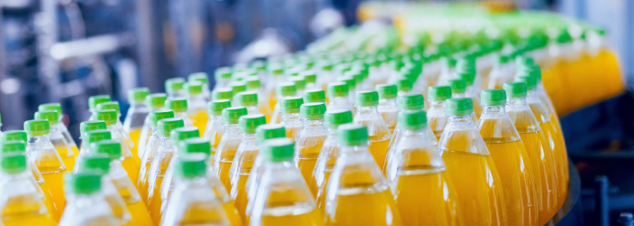 Plastic bottles of orange juice on a factory conveyor belt