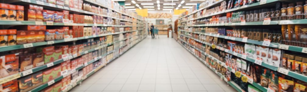 A person in yellow overalls and a face mask moves a blue container with a toxic skull and crossbone warning on the side