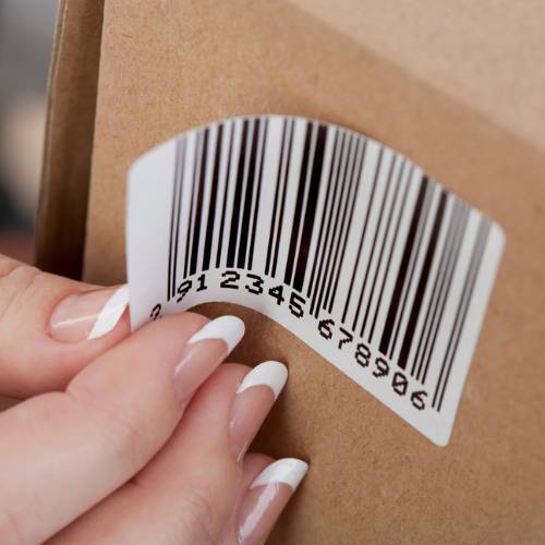 Graphic showing someone peeling a barcode sticker off a cardboard box