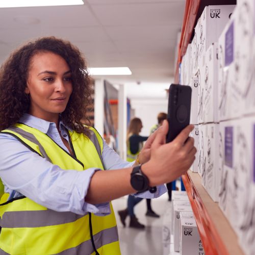 Someone scanning stock on some racking, with their mobile phone