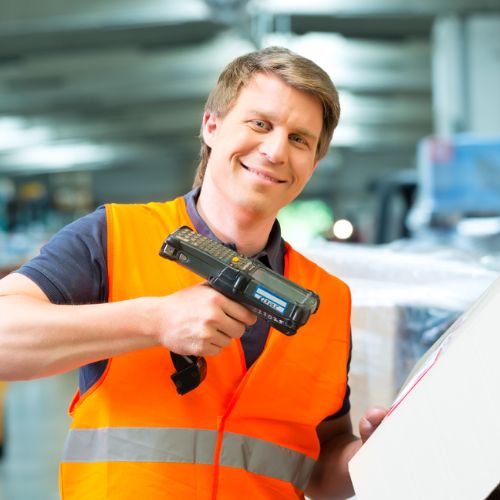 Warehouse worker in orange high visibility vest operating a hand held barcode scanner